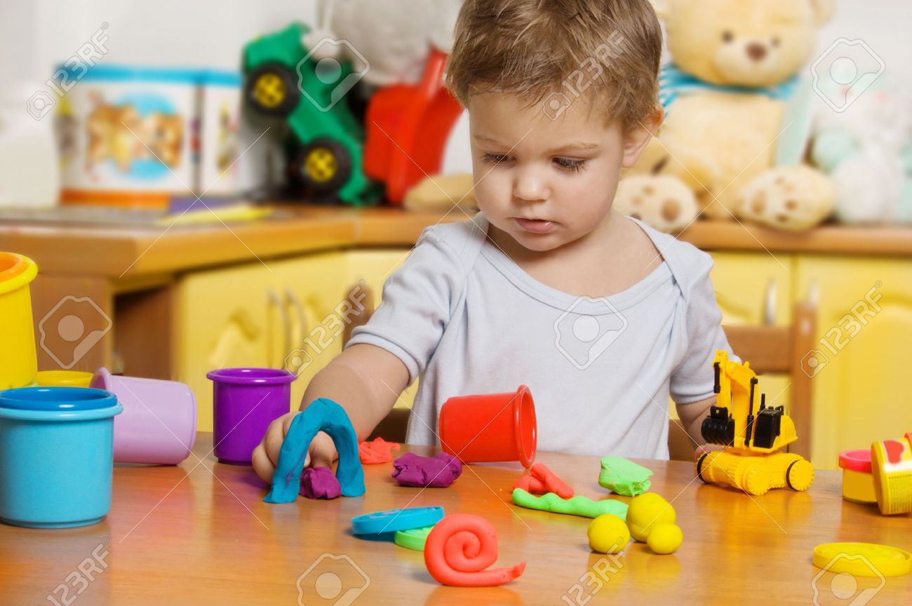 7667530 figlio di 2 anni plastilina nella camera dei bambini di giocare Archivio Fotografico